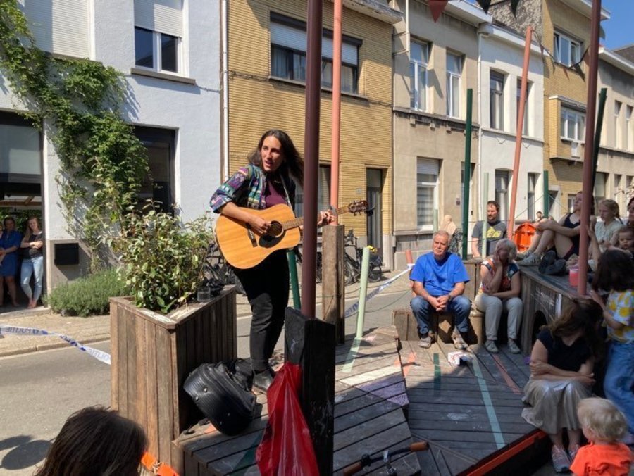 Foto van gitarist op een parklet bij een buurtfeest